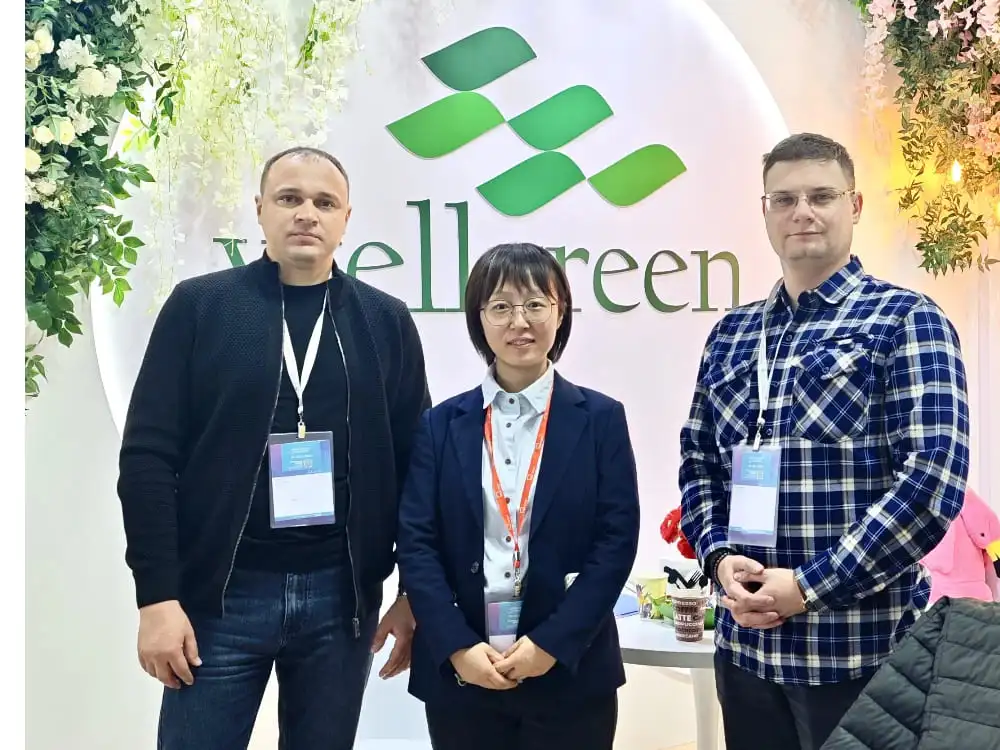 The Wellgreen team poses for a group photo with partners and clients at their exhibition booth, symbolizing successful collaboration.