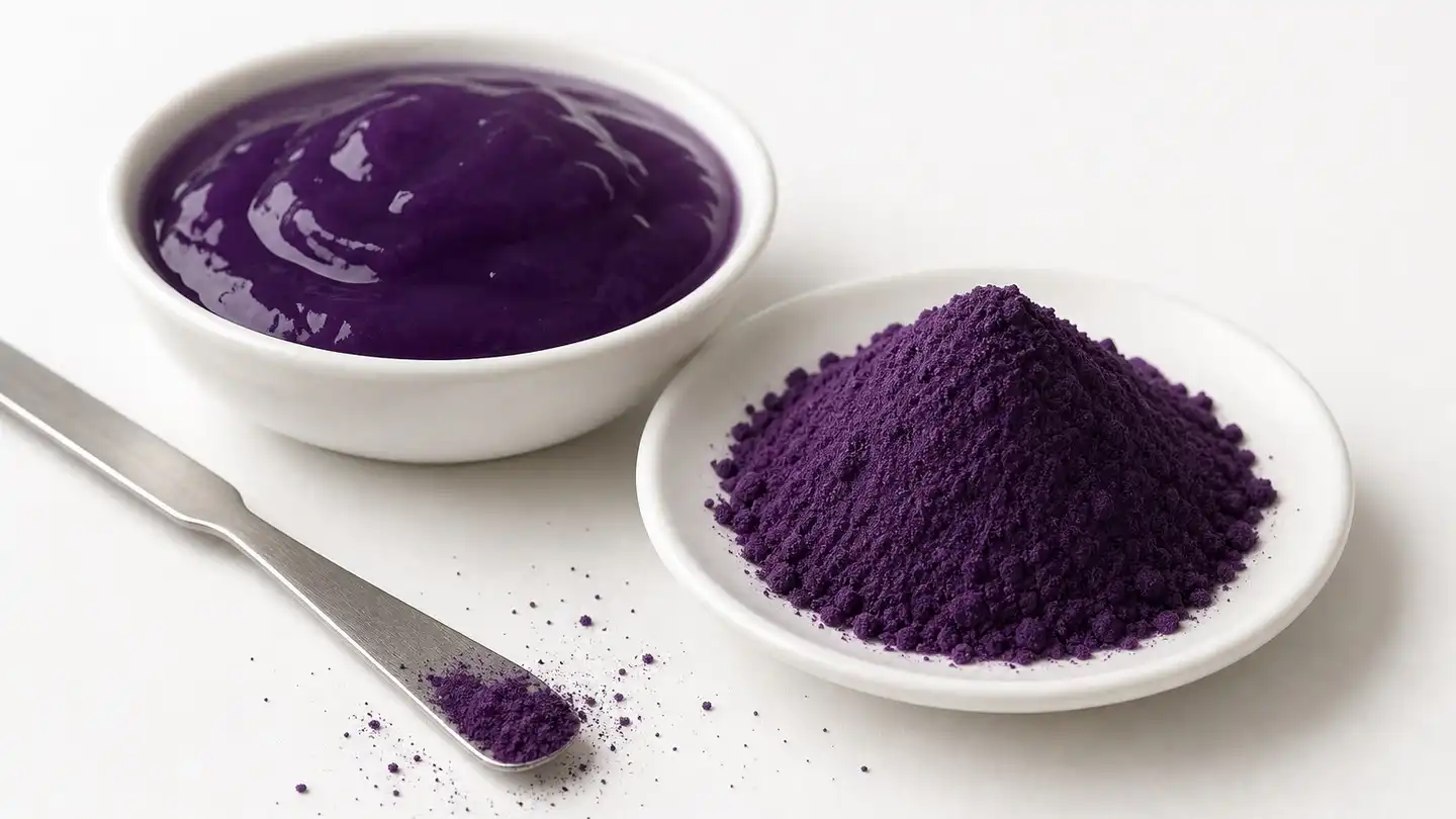 blog-500-1 Small mound of fine deep purple ube powder beside a white dish of glossy purple gel with a stainless steel spatula on a clean white studio surface